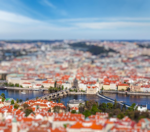 Aerial view of Charles Bridge over Vltava river and Old city from Petrin hill Observation Tower with tilt shift toy effect shallow depth of field Prague Czech Republic