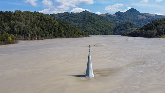Aerial view of church tower in geamana flooded village by\
mining residuals, romania
