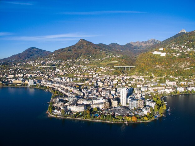 Aerial view of city by sea against sky