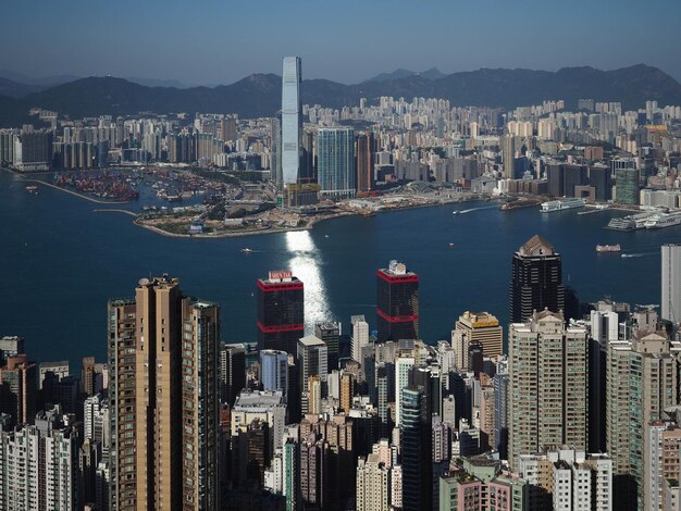 Aerial view of city by sea and buildings against sky