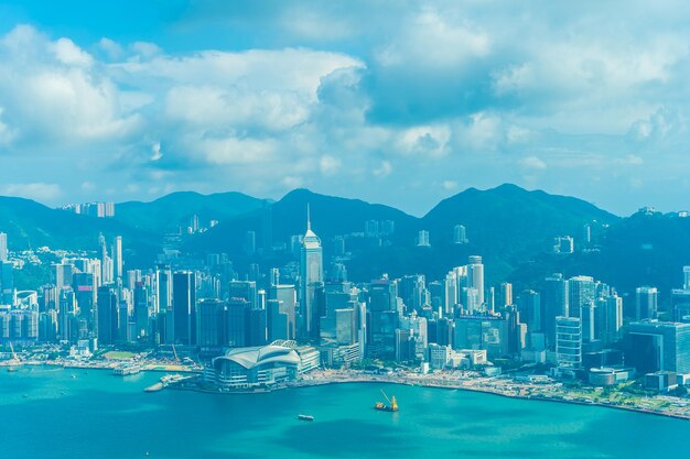 Aerial view of city at waterfront against cloudy sky