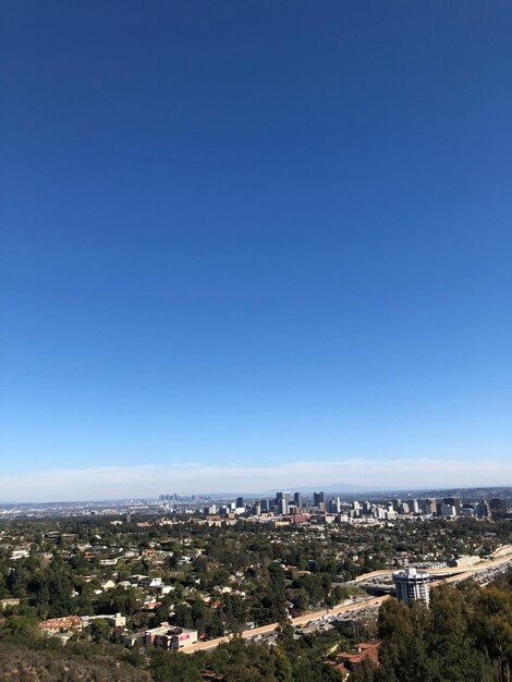 Aerial view of cityscape against clear blue sky