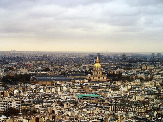 Aerial view of cityscape against cloudy sky