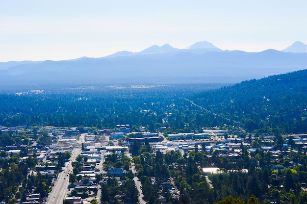 aerial view of cityscape by mountains against sky