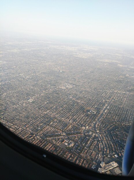 Photo aerial view of cityscape seen through airplane window