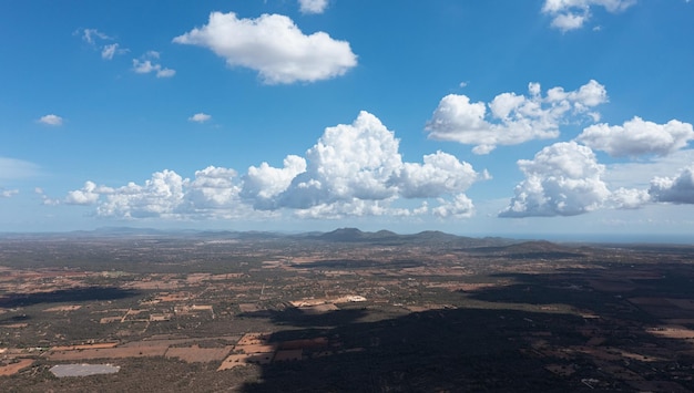 Aerial view of the clouds casting shadows over the countryside with the mountains on the backgrounds