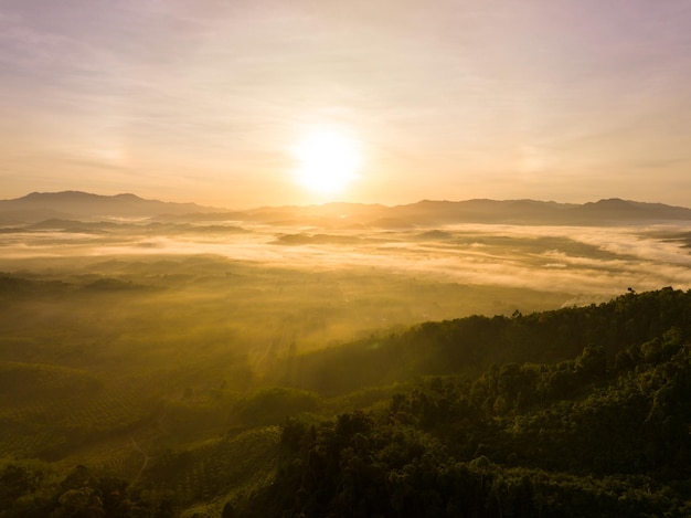 Aerial view colorful sky over mountains tropical rainforestBird eye view image over the fog Amazing nature background with clouds and mountain peaks in Thailand
