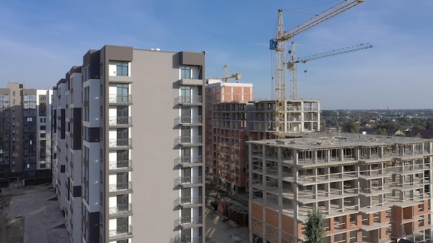 Aerial view of concrete frame of tall apartment building under construction in a city.