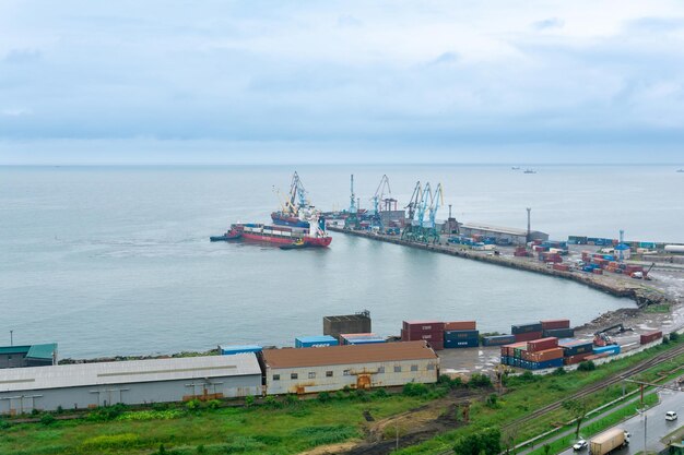 Aerial view of the container cargo terminal of the port of Korsakov on Sakhalin Russia with a container ship moored with the help of tugs