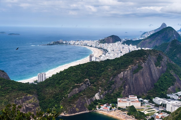 Veduta aerea della spiaggia di copacabana con i suoi edifici mare e paesaggio enormi colline lungo l'intera lunghezza immensità della città di rio de janeiro brasile sullo sfondo