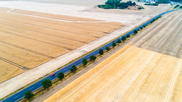 Photo aerial view of a country road between agricultural fields in europe germany beautiful landscape captured from above with a drone