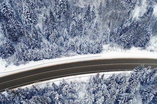 Photo aerial view of a curved mountain road aerial view of a curved mountain road in europe. winter mountain landscape. snow-covered trees and mountain slopes. drone view.europe.