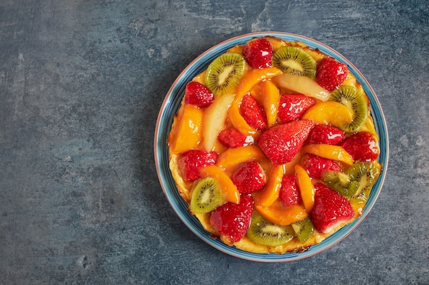 Aerial view of a delicious tart with fresh seasonal fruits and cream.