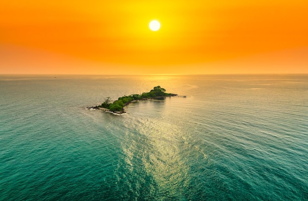 タイ湾の青緑色の水と夕焼け空を背景に無人島の空撮