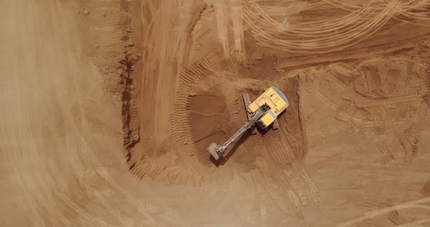 Aerial view of a digger, tracked excavator at work on a construction.