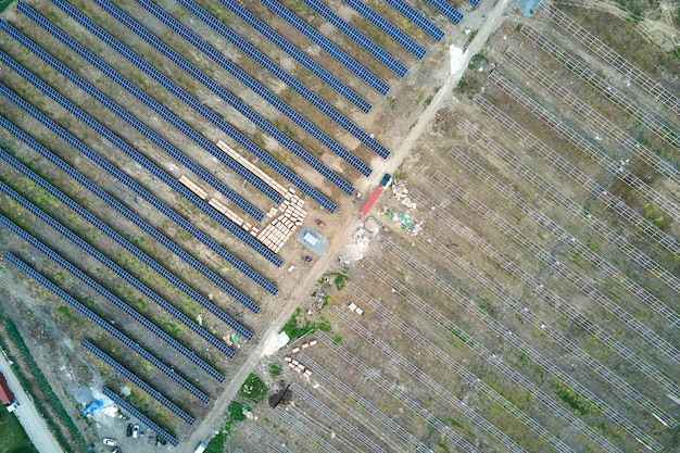 Aerial view of electrical power plant under construction with truck delivering assembly parts for solar panels on metal frame for producing electric energy Development of renewable electricity