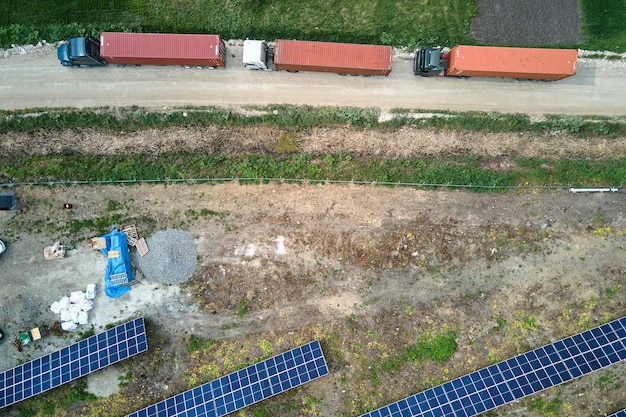 Aerial view of electrical power plant under construction with truck delivering assembly parts for solar panels on metal frame for producing electric energy Development of renewable electricity