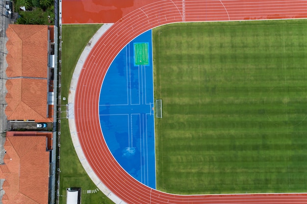 Aerial view of empty new soccer field from above with running tracks around it Amazing new small stadium for many sport disciplines at phuket thailand.