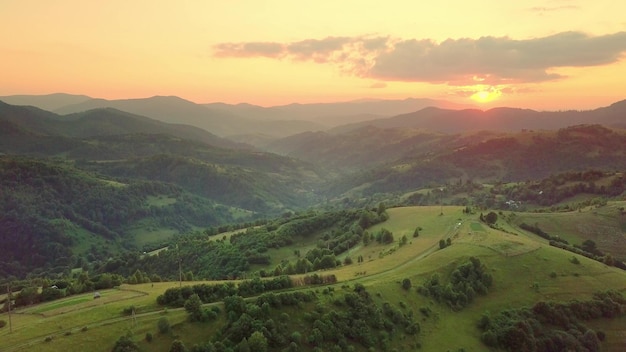 Aerial view of the endless lush pastures of the Carpathian expanses and agricultural land Cultivated agricultural field Rural mountain landscape at sunset Ukraine