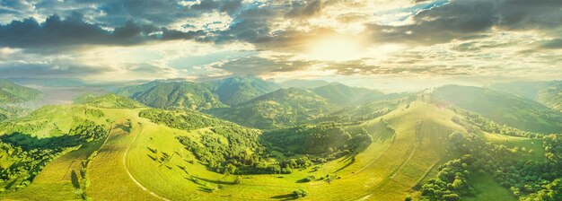 Aerial view of the endless lush pastures of the Carpathian expanses and agricultural land Cultivated agricultural field Rural mountain landscape at sunset Ukraine