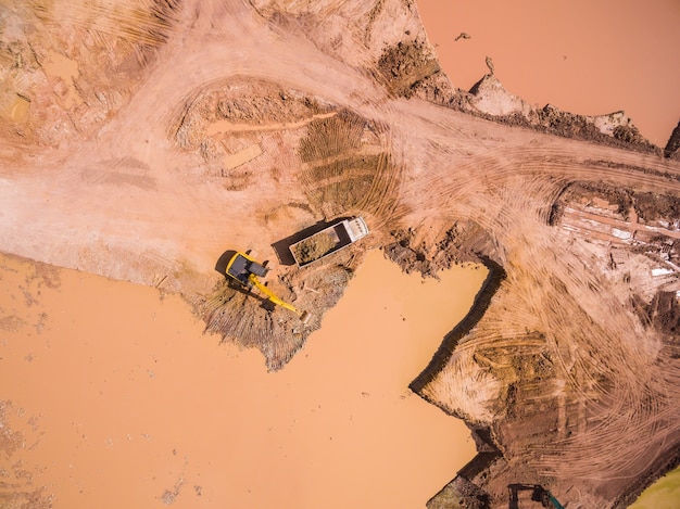 Photo aerial view of excavator and truck working