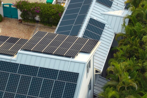 Aerial view of expensive american home roof with blue solar photovoltaic panels for producing clean ecological electric energy Investing in renewable electricity for retirement income