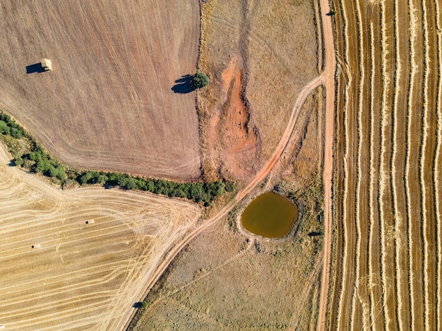 Aerial view of farm fields, dirt roads and water basin.