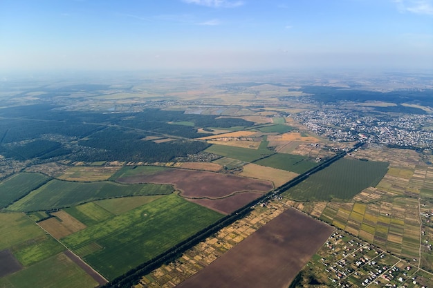 Aerial view of farm fields and distant scattered houses in rural area