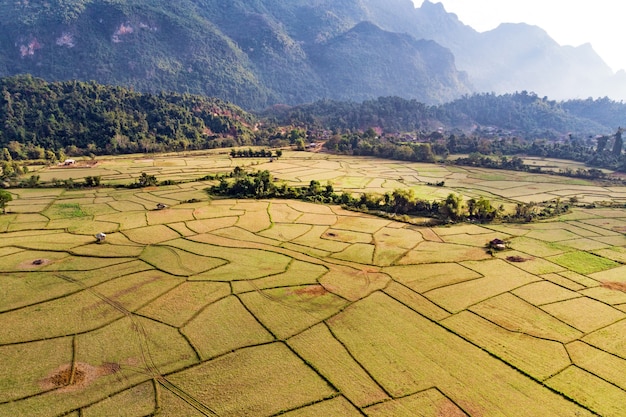 Aerial view of farm fields and rock formations in Vang Vieng, Laos. Vang Vieng is a popular destination for adventure tourism in a limestone karst landscape.