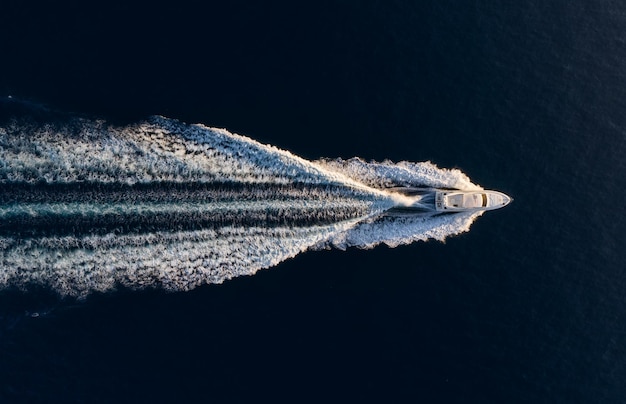 Вид с воздуха на скоростной лодке на синем Средиземном море в солнечный день Быстрый корабль на поверхности моря Морской пейзаж с дрона Морской пейзаж с воздуха Изображение путешествия