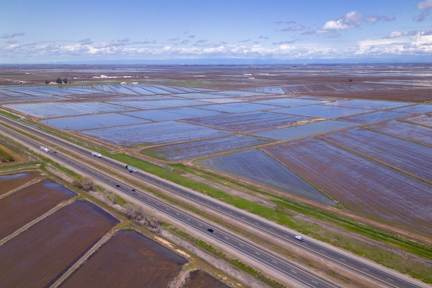 Aerial view of a field with a road farmland on California rice plantation