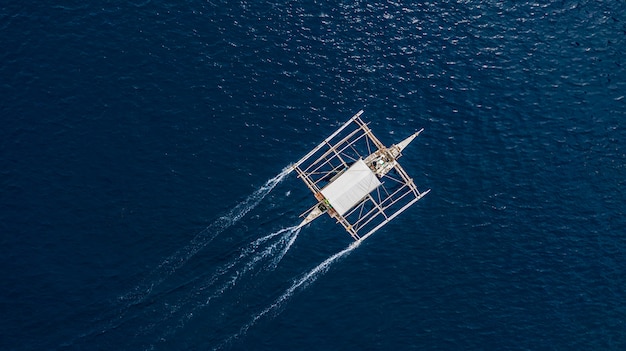 澄んだ青い海の上に浮かぶフィリピンのボートの空撮