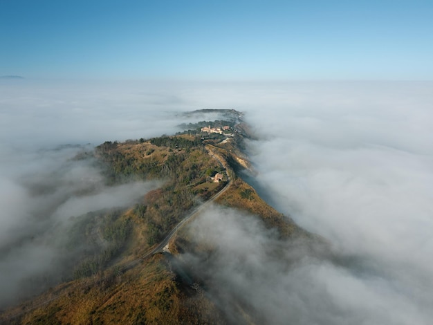 Photo aerial view of fiorenzuola di focara immersed in fog italy