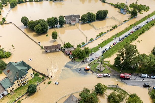 Foto vista aerea di case allagate e veicoli di soccorso per salvare le persone nella città di halych, ucraina occidentale.