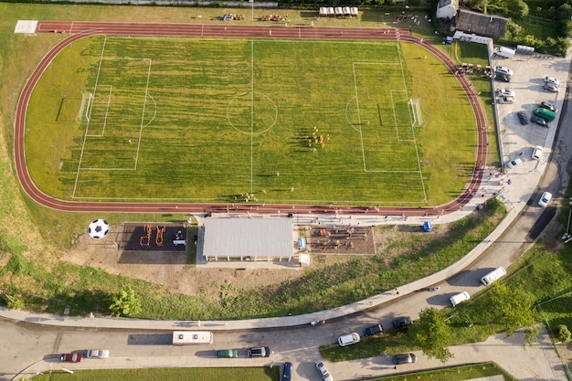 田園地帯の緑の草で覆われたスタジアムのフットボール競技場の空撮。