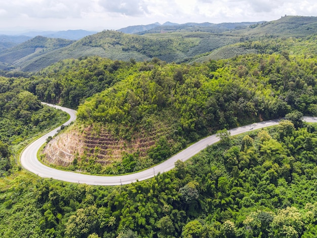 Vista aerea della natura della foresta con auto sulla strada sull'albero verde di montagna, curva stradale vista dall'alto dall'alto, vista a volo d'uccello strada attraverso la montagna la foresta verde bellissimo ambiente fresco