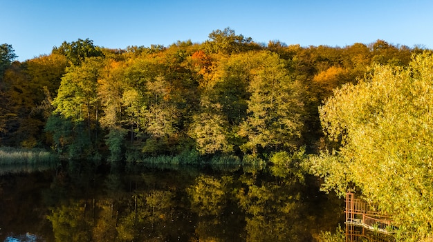 aerial view of forest with yellow trees and beautiful lake landscape from above, Kiev, Goloseevo forest, Ukraine