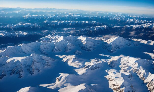 Aerial View from Airplane of Blue Snow Covered Mountain Landscape in Winter