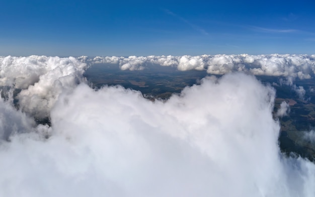 写真 暴風雨の前に形成されるふくらんでいる積雲で覆われた地球の高高度での飛行機の窓からの空中写真。