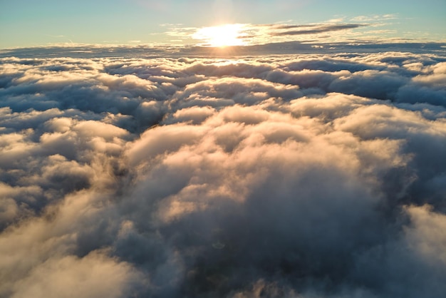 夕方に飛んでいる高密度のふくらんでいる積雲の高高度での飛行機の窓からの空中写真