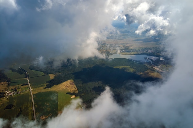 Foto vista aerea dalla finestra dell'aeroplano ad alta quota di terra ricoperta di nuvole cumuliformi gonfie che si formano prima del temporale.