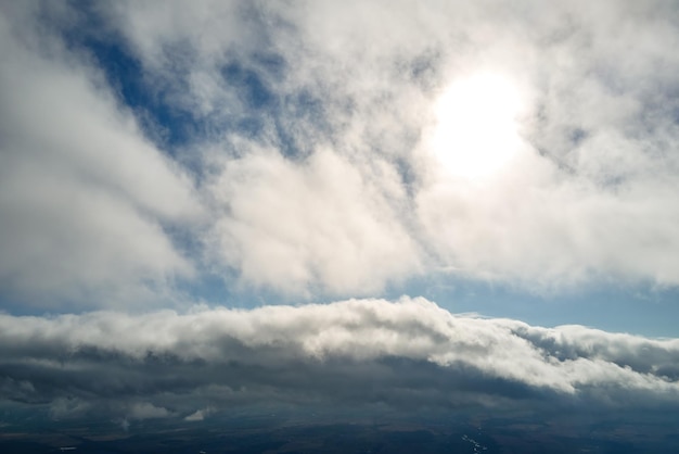 흰색 푹신한 적운 구름으로 덮인 지구의 높은 고도에서 비행기 창에서 공중보기