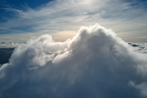 Aerial view from airplane window at high altitude of earth covered with white puffy cumulus clouds