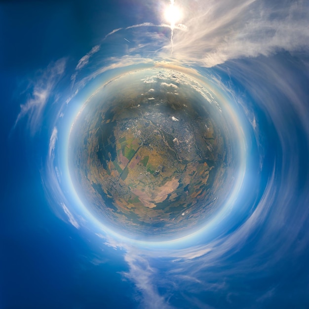 Aerial view from airplane window at high altitude of little planet earth covered with white thin layer of misty haze and distant clouds at sunset.