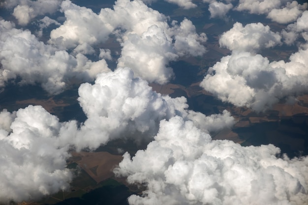 밝고 화창한 날 비행기 창에서 하얀 푹신한 구름의 공중 전망.