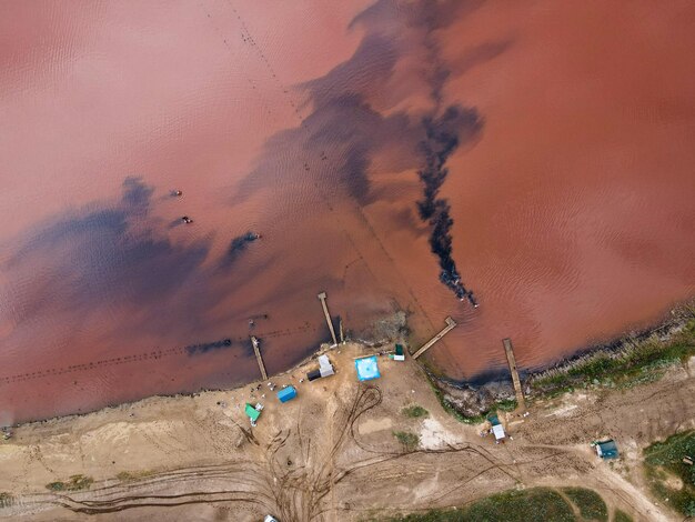 Aerial view from a drone on people who bathe in dirty water rusty color outdoor