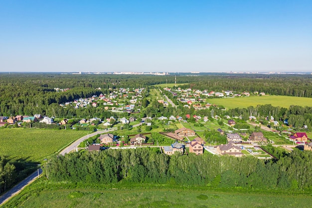 aerial view from a drone of a rural village, fields and forests around