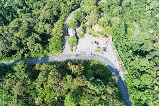 プーケットタイの緑の森とアスファルト道路曲線のドローン上面図からの空中写真