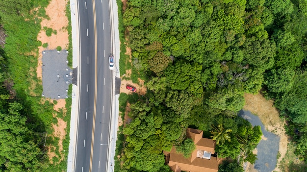 緑の森とアスファルトの道路のドローン上面から空撮