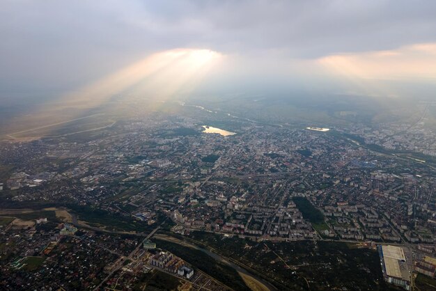 Aerial view from high altitude of distant city covered with puffy cumulus clouds forming before rainstorm in evening Airplane point of view of cloudy landscape